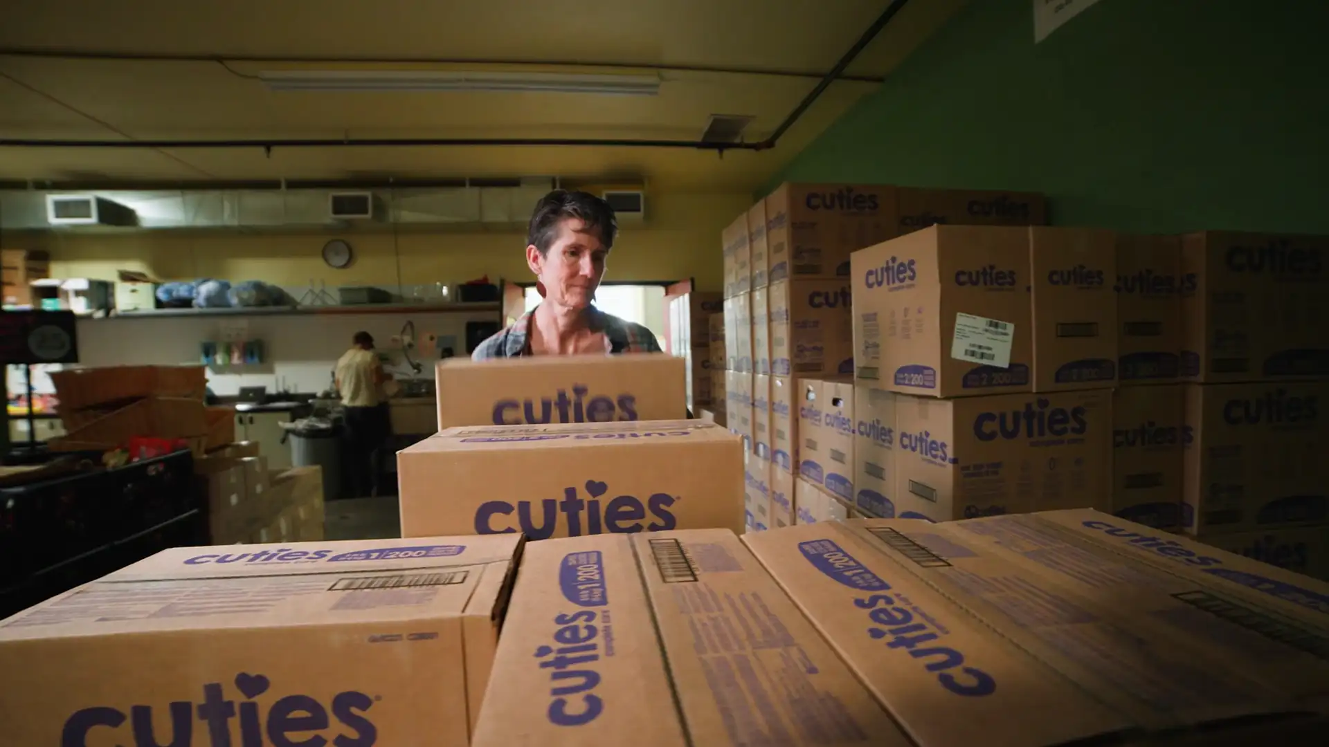 Volunteer moving box of donated diapers